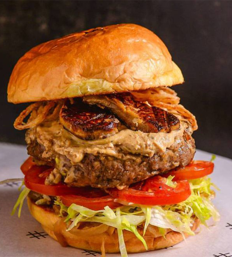 A classic burger featuring a perfectly grilled beef patty, crisp lettuce, juicy tomatoes, and a buttery brioche bun.